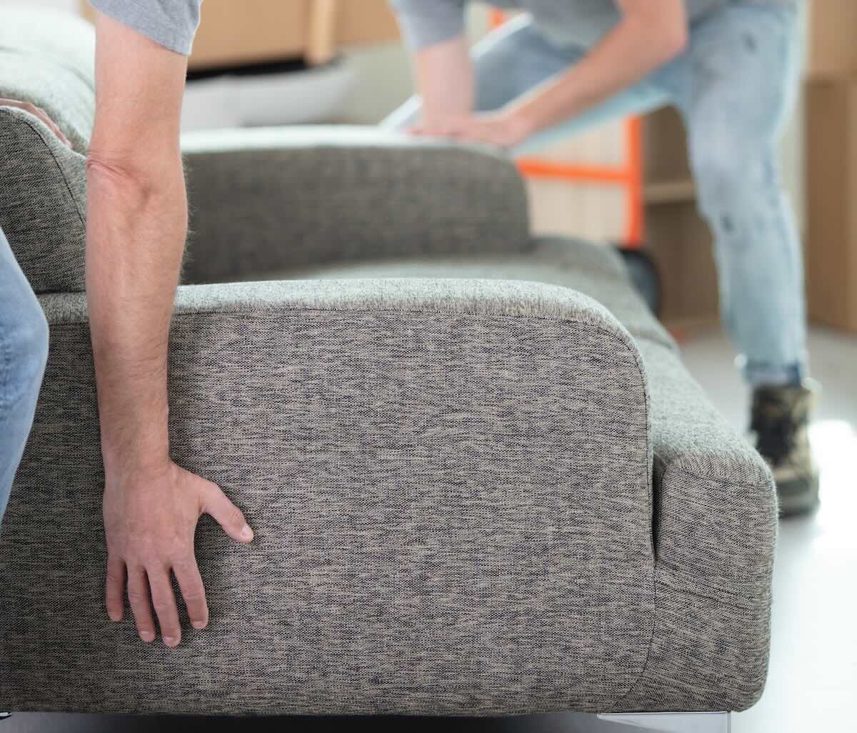 Movers carrying boxes through an apartment building hallway