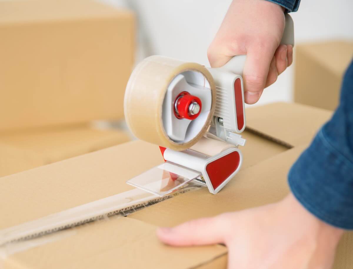 Professional packers wrapping and boxing household items